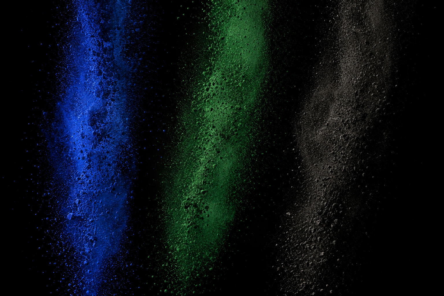 Symbolische Inszenierung rieselnder blauer, grüner und anthrazitfarbener Pigmente